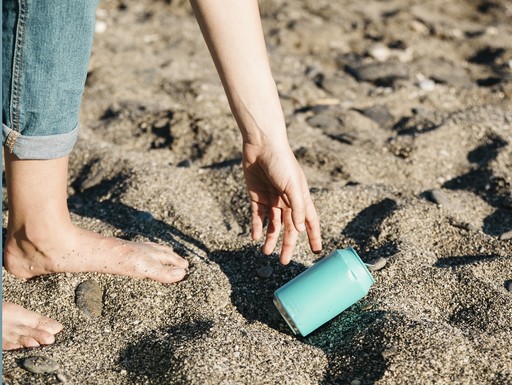 Eldobott fémdobozért hajol le egy kéz a strandon, Kép: jofogas.hu