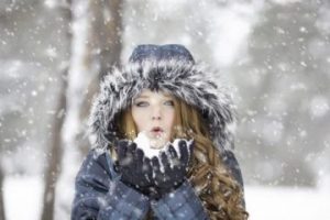 Fiatal lány hóesésben, kapucniban havat fúj, Kép: pixabay