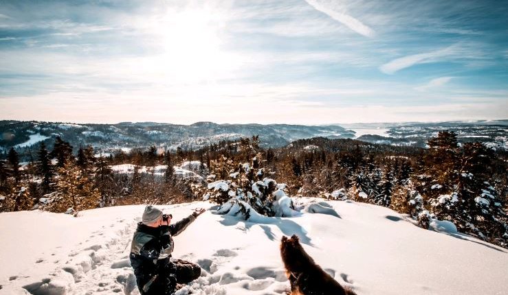 Téli hegycsúcs, fényképező ember és kutyája, Kép: pxhere