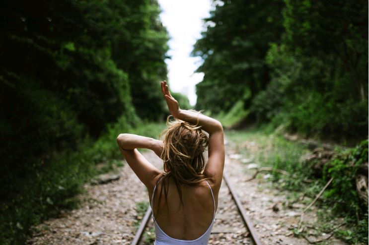 Nő feltartott kézzelmaz erdőben, sínek között, nyár, Kép: pxhere
