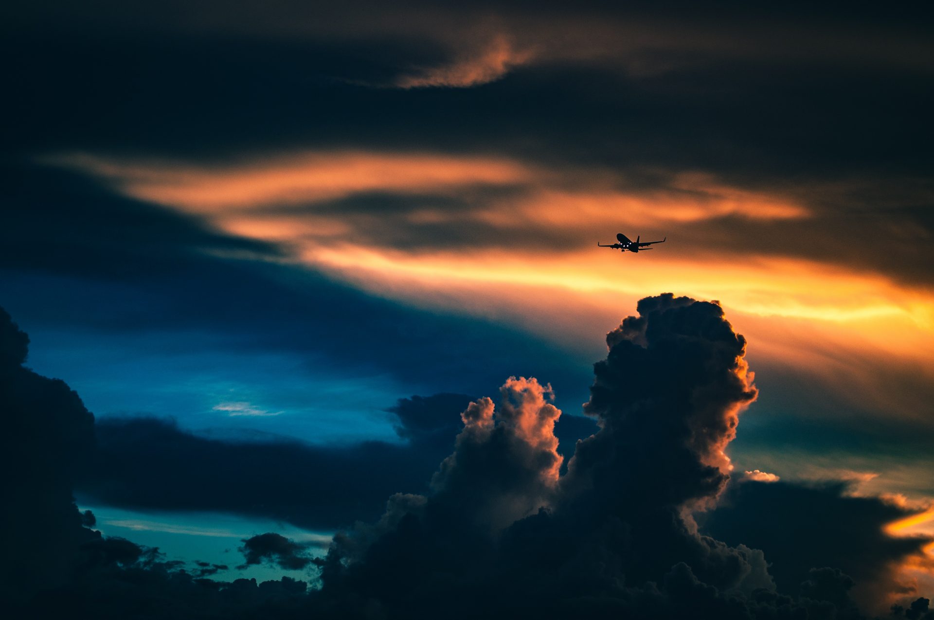 Repülőgép, mögötte napvilágította felhők, Kép: legiseged.hu