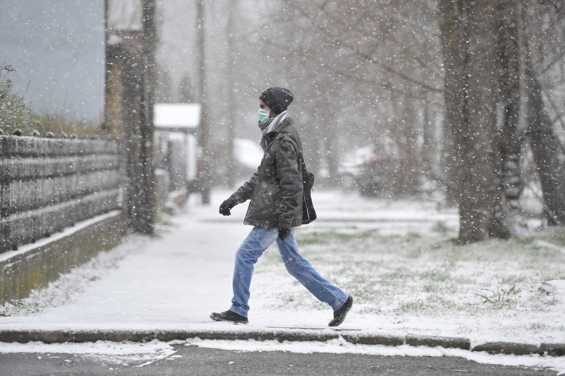 Szájmaszkban, hóeseésben sétáló férfi Debrecenben, Kép: Czeglédi Zsolt, MTI